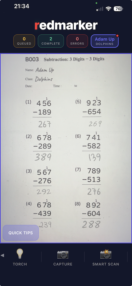Phone camera screen framing a printed Kumon-style maths drill sheet on a table, ready to photograph.